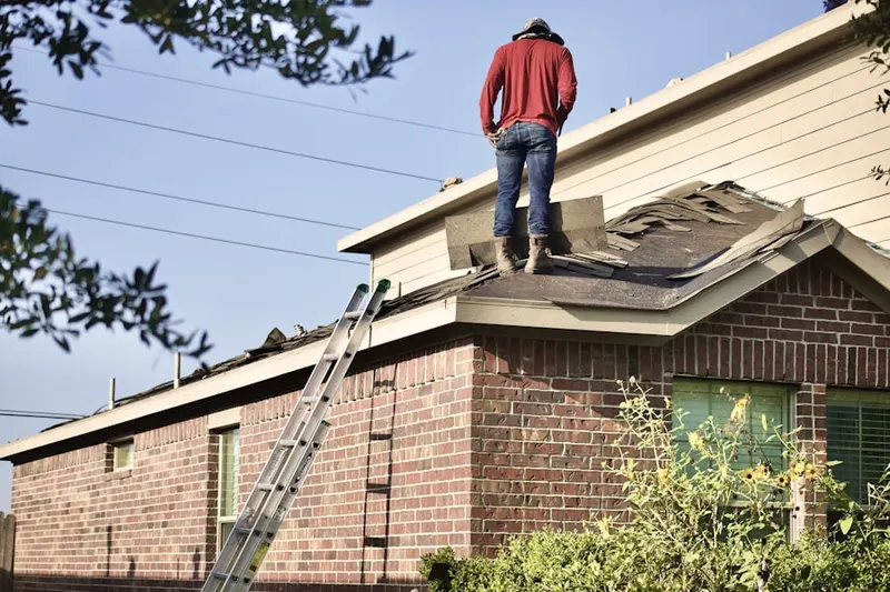 Professional roofer working on a residential roof in Belden